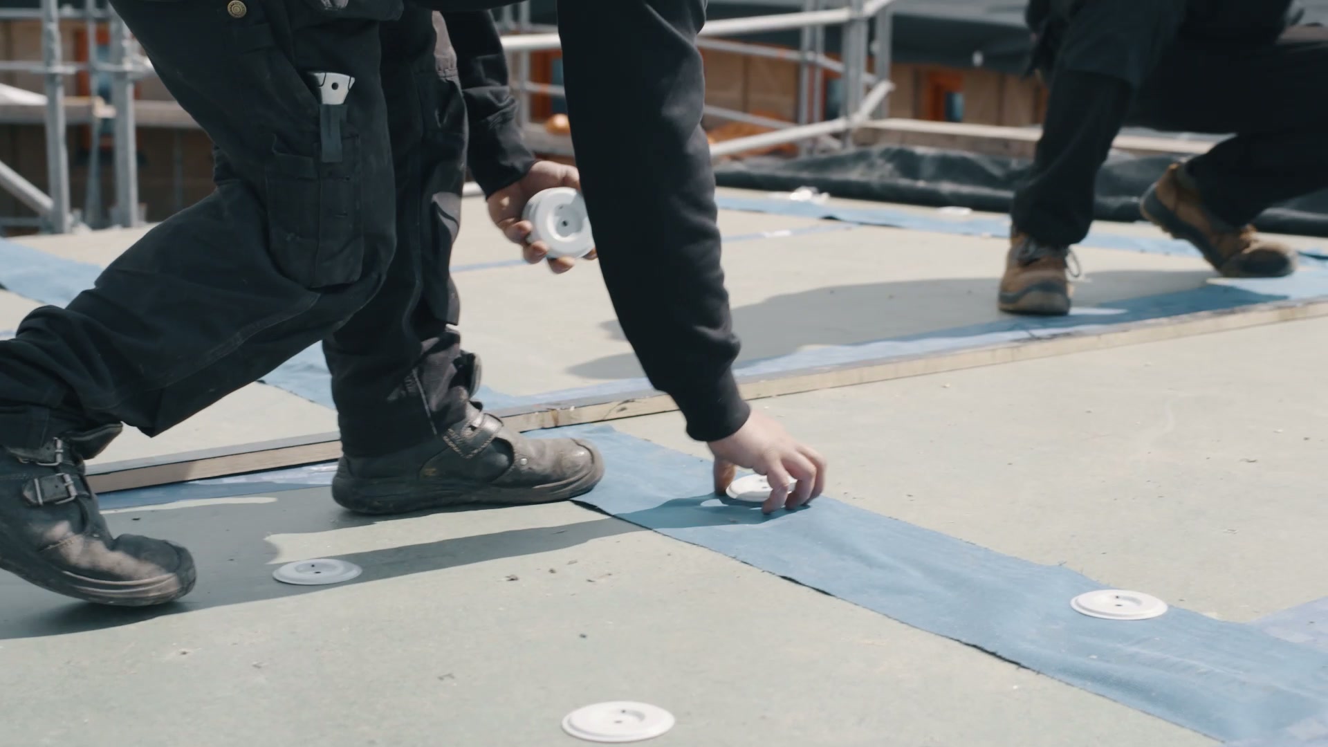 Coated induction plates installed across the flat-roof insulation layer
