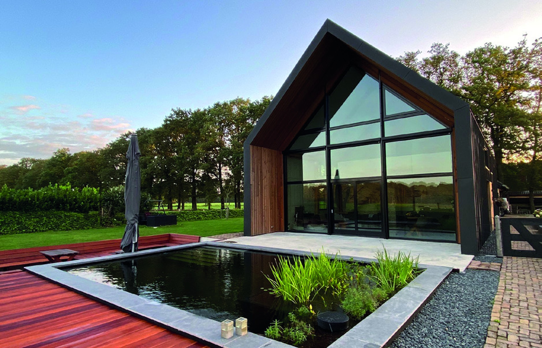 Completed ECOLAN-lined reflecting pond beside a timber and glass pavilion